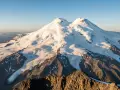 Elbrus, najwyższa góra Europy, lśni w słońcu. Jej ośnieżone szczyty i lodowce tworzą majestatyczny krajobraz.