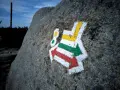 Kolorowe szlaki turystyczne (czerwony, zielony, żółty) namalowane na skale.