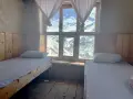 Pokój z dwoma łóżkami i widokiem na ośnieżone góry. Idealne miejsce na odpoczynek po trekkingu na Annapurna Circuit.