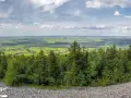 Widok z góry na zielone pola i lasy, idealne na odkrywanie fajnych miejsc w świętokrzyskim.