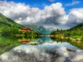 Słowackie Tatry zachwycają. Jezioro z odbiciem chatki i gór to idealne miejsce na tatry słowackie szlaki z dzieckiem.