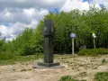 Granitowy obelisk z herbami Słowacji i Ukrainy na szczycie góry w Bieszczadach.
