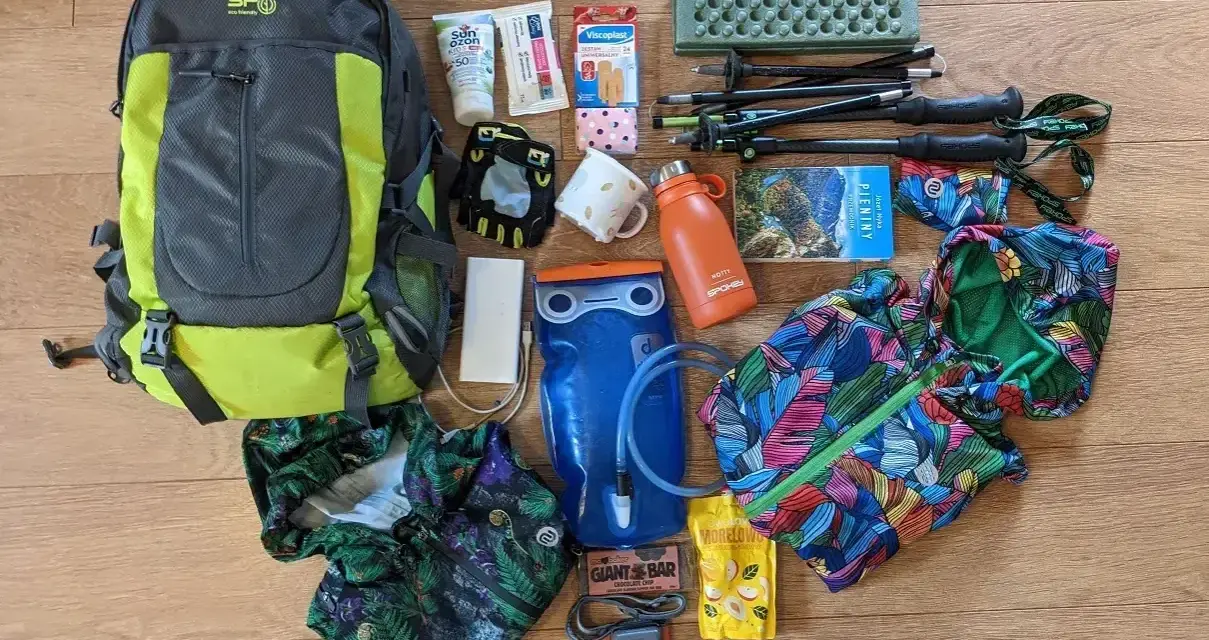 Plecak, kijki trekkingowe, bukłak, kurtka przeciwdeszczowa i inne niezbędne przedmioty tworzą kompletny ekwipunek w góry.