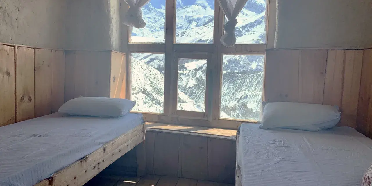 Pokój z dwoma łóżkami i widokiem na ośnieżone góry. Idealne miejsce na odpoczynek po trekkingu na Annapurna Circuit.