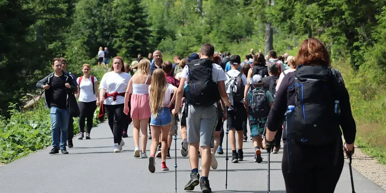 Grupa turystów wędruje po Tatrach. Wśród nich są nosicze, których zarobki zależą od ciężaru bagażu.