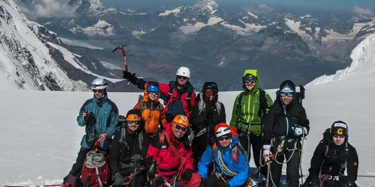 Grupa alpinistów na tle majestatycznego Monte Rosa, gotowa do zdobycia szczytu.