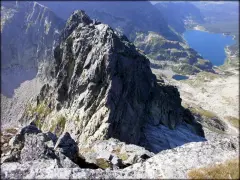 Widok z przełęczy na skraju Orlej Perci na skaliste szczyty i turkusowe jeziora w Tatrach.