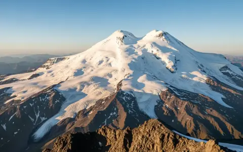Elbrus, najwyższa góra Europy, lśni w słońcu. Jej ośnieżone szczyty i lodowce tworzą majestatyczny krajobraz.