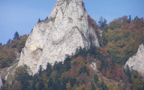 Trzy Korony, nazwy szczytów w Pieninach, majestatycznie wznoszą się na tle błękitnego nieba, otoczone jesienną paletą barw lasów.