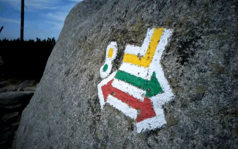 Kolorowe szlaki turystyczne (czerwony, zielony, żółty) namalowane na skale.