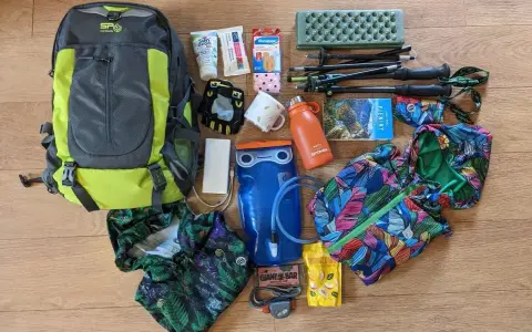 Plecak, kijki trekkingowe, bukłak, kurtka przeciwdeszczowa i inne niezbędne przedmioty tworzą kompletny ekwipunek w góry.