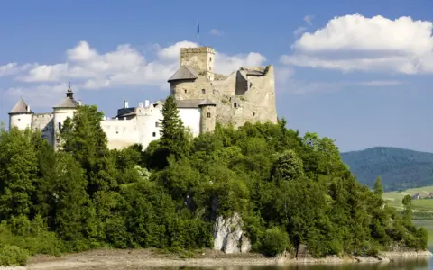 Zamek w Niedzicy, malowniczo położony nad jeziorem, kryje wiele ciekawostek. Otoczony zielenią, z wieżą górującą nad okolicą, zaprasza do odkrywania historii.