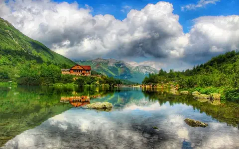 Słowackie Tatry zachwycają. Jezioro z odbiciem chatki i gór to idealne miejsce na tatry słowackie szlaki z dzieckiem.