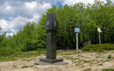 Granitowy obelisk z herbami Słowacji i Ukrainy na szczycie góry w Bieszczadach.