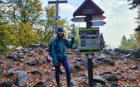 Kobieta na szczycie Łysicy, 614 m n.p.m., przy drogowskazie szlaku łysica - kakonin. Jesień w pełni, liście na ziemi.