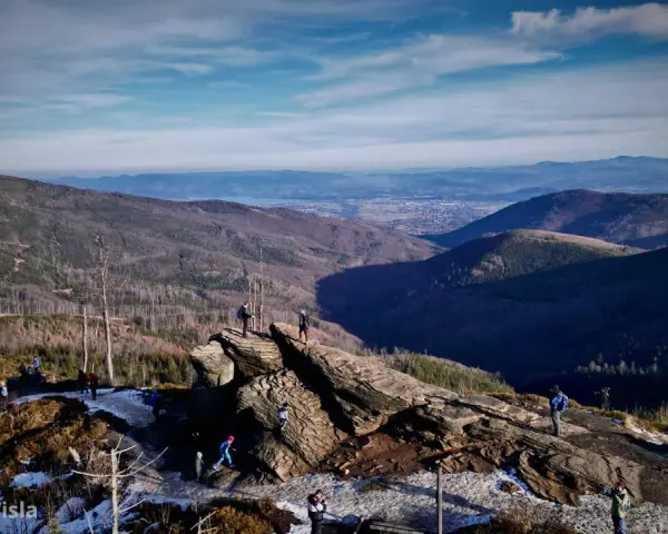 Widok na Beskidy z Wisły. Grupa turystów podziwia panoramę gór i doliny.