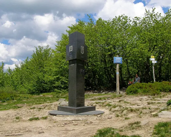 Granitowy obelisk z herbami Słowacji i Ukrainy na szczycie góry w Bieszczadach.