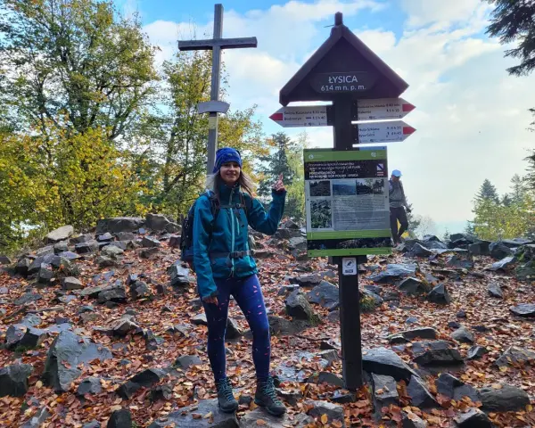 Kobieta na szczycie Łysicy, 614 m n.p.m., przy drogowskazie szlaku łysica - kakonin. Jesień w pełni, liście na ziemi.