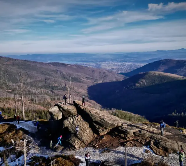 Widok na Beskidy z Wisły. Grupa turystów podziwia panoramę gór i doliny.