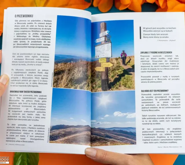 Widok na malownicze **Bieszczady** z połonin. Na pierwszym planie drogowskazy, w tle turystka.