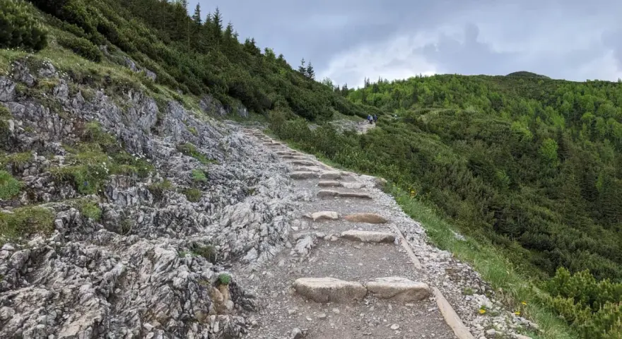 Kamieniste schody prowadzą w górę, przez zielone zbocza porośnięte kosodrzewiną. To szlak do Murowańca, gdzie czeka schronisko.