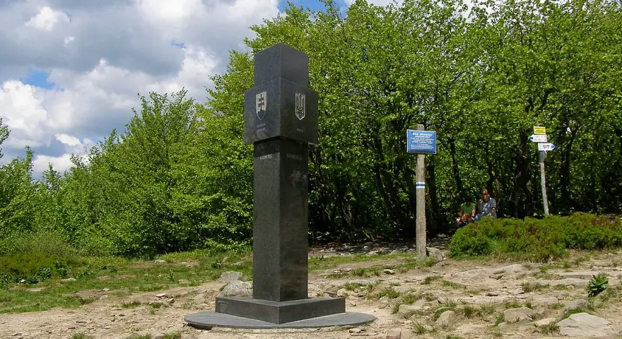 Granitowy obelisk z herbami Słowacji i Ukrainy na szczycie góry w Bieszczadach.