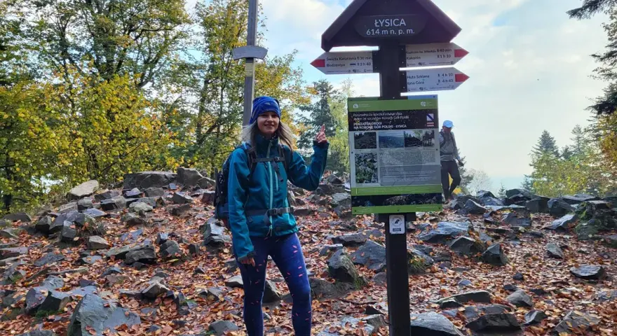 Kobieta na szczycie Łysicy, 614 m n.p.m., przy drogowskazie szlaku łysica - kakonin. Jesień w pełni, liście na ziemi.