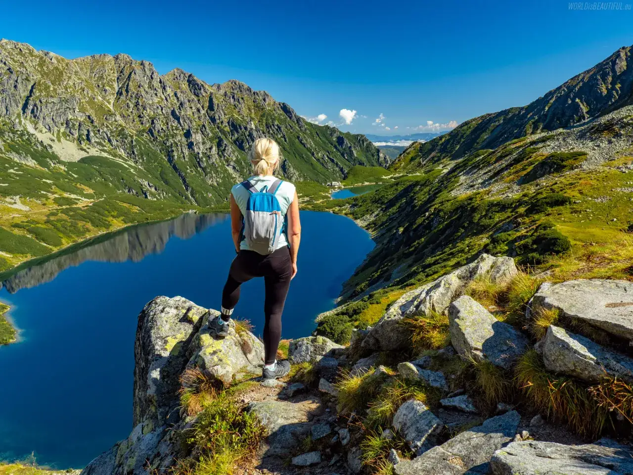 Kobieta z plecakiem podziwia widok na Tatry. Trasa na Szpiglasowy Wierch oferuje takie krajobrazy.