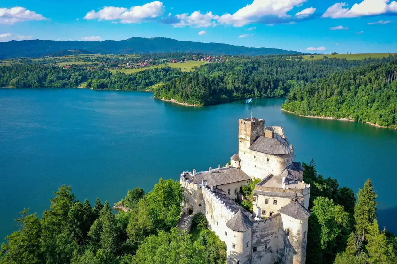 Zamek w Niedzicy, malowniczo położony nad jeziorem, kryje wiele ciekawostek. Otoczony zielenią, z wieżą górującą nad wodą, zaprasza do odkrywania historii.