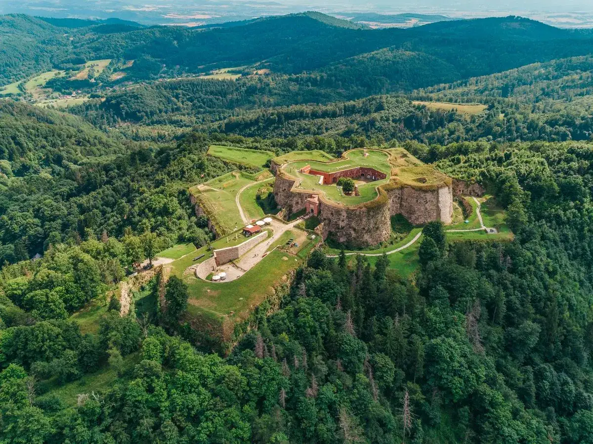 Forteczne Srebrna Góra, imponujące atrakcje turystyczne, otoczone zielonymi wzgórzami i lasami.