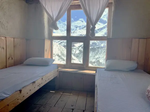 Pokój z dwoma łóżkami i widokiem na ośnieżone góry. Idealne miejsce na odpoczynek po trekkingu na Annapurna Circuit.
